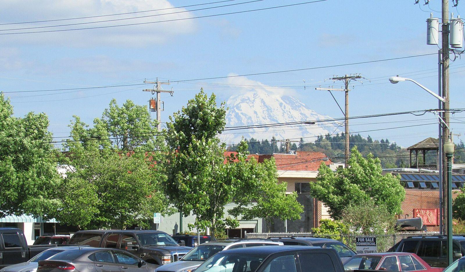 Downtown Puyallup street with Mount Rainier visible above the buildings on a clear day