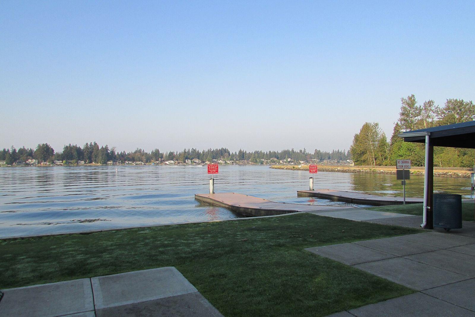 Docks and a grassy shoreline at Lake Tapps North Park on a clear evening