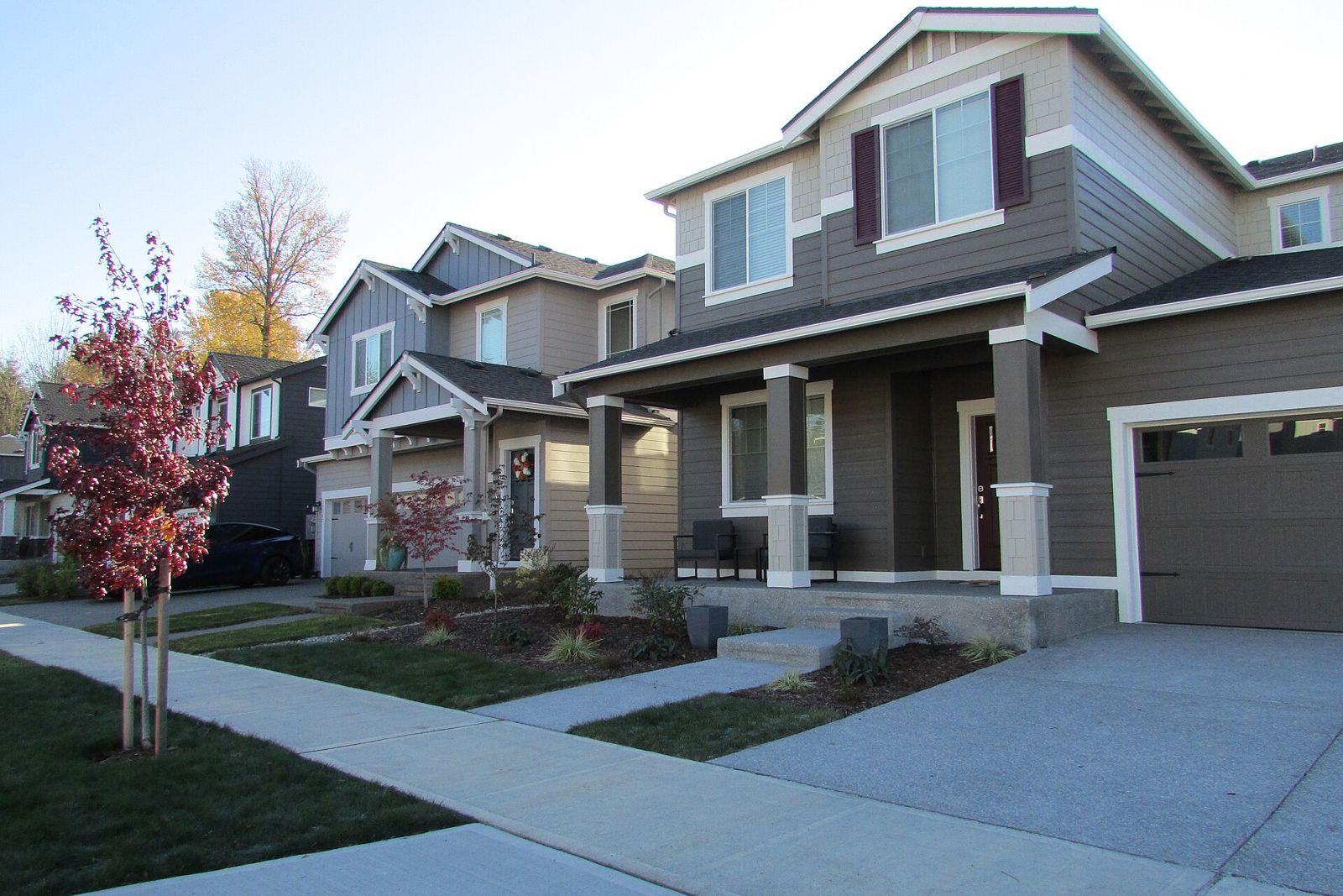 Quiet residential street with two story homes and autumn trees in Tehaleh
